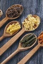 A set of raw pastas on spoons on a wooden table Royalty Free Stock Photo