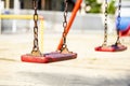 Set of red chain swings on modern kids playground Royalty Free Stock Photo