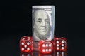 Set of red game cubes and a bundle of American dollars, on a black background, with reflection Royalty Free Stock Photo