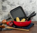 a set of red pans with vegetables on a wooden table Royalty Free Stock Photo