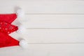 Set of red santa claus hats on white wooden background with copy space. For holiday sales. New Year`s and Christmas Royalty Free Stock Photo