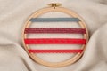 Set of red sewing ribbons on hoop over beige background