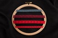 Set of red sewing ribbons on hoop over black background