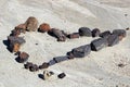 A set of rocks in the shape of a heart in the dried mud Royalty Free Stock Photo