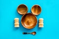 Set of rustic wooden tableware - bowls and utensils on blue background top view