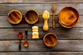 Set of rustic wooden tableware - bowls and utensils on dark wooden background top view pattern