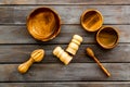 Set of rustic wooden tableware - bowls and utensils on dark wooden background top view pattern