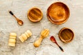 Set of rustic wooden tableware - bowls and utensils on grey background top view