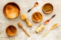 Set of rustic wooden tableware - bowls and utensils on grey background top view pattern