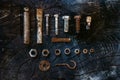 Set of rusty screws, nuts and small tools on a dark wooden background. Royalty Free Stock Photo