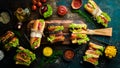 Set of sandwiches and burgers on a wooden kitchen board. On a stone background. Royalty Free Stock Photo