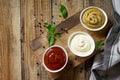 Set of sauces - ketchup, mayonnaise and mustard sauce on a wooden table.