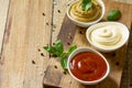 Set of sauces - ketchup, mayonnaise and mustard sauce on a wooden table.