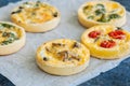 Set of savory mini tarts on a baking paper. Vegetable quiches wi Royalty Free Stock Photo