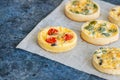 Set of savory mini tarts on a baking paper. Vegetable quiches wi Royalty Free Stock Photo