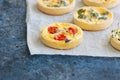 Set of savory mini tarts on a baking paper. Vegetable quiches wi