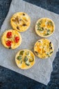 Set of savory mini tarts on a baking paper. Vegetable quiches wi Royalty Free Stock Photo