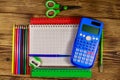 Set of school stationery supplies. Blank notepad, calculator, rulers, pencils, pens, scissors and sharpener on wooden desk Royalty Free Stock Photo