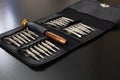 A set of screwdrivers in a leather case on wooden table Royalty Free Stock Photo