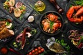 Set of seafood dishes. Fish, squid, octopus on a black stone background. Top view.