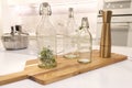 A set of sealed glass bottles of different sizes stands on a cutting wooden board in the kitchen. Kitchen interior, cooking Royalty Free Stock Photo