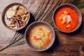 Set of Serving Asian Soups on gray background top view. Tom Yum Soup, Eel Fish Soup and Ramen noodle Soup. Royalty Free Stock Photo