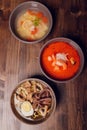 Set of Serving Asian Soups on gray background top view. Tom Yum Soup, Eel Fish Soup and Ramen noodle Soup. Royalty Free Stock Photo