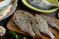 A set of fresh, raw fish in various dishes and with vegetables on a black table Royalty Free Stock Photo