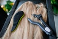 A set of several hair extension tools for a blonde woman in a beauty salon. Pliers and micro tubes