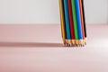 A set of sharpened multi-colored pencils, standing on a white-pink background on the right side, with a slight shadow. Horizontal Royalty Free Stock Photo