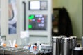 A set of shiny collet chucks in metalworking shop with blurry cnc milling machine inn the background