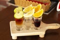 A set of layered cocktails in glasses shooters with fruit as a snack for