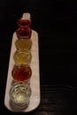 A set of shots with strong alcohol in small glass cups on a wooden tray on the table. National ukraiskih alkolol