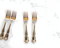 A set of silver cocktail forks displayed on a marble table surface Royalty Free Stock Photo