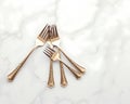 A set of silver cocktail forks displayed on a marble table surface Royalty Free Stock Photo