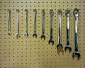A set of silver metal wrench hand tools in a row hanging