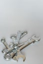 Set of silver metallic spanners, isolated objects. Pile of wrenches / spanners. Vertical photo in very soft focus.