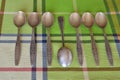 A set of silver teaspoons with a spoon from another set turned upside down.