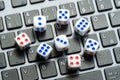 A set of simple small game dice showing different numbers laying on a laptop computer keyboard, random numbers generation Royalty Free Stock Photo