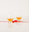 Set of single malt tasting glasses, single malt whisky in a glasses, white background, red bow Royalty Free Stock Photo