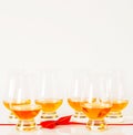 Set of single malt tasting glasses, single malt whisky in a glasses, white background, red bow Royalty Free Stock Photo