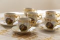 A set of six festive, decorated, painted cups built on a gold embroidered Christmas tablecloth Royalty Free Stock Photo