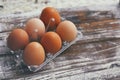 Set of six fresh brown eggs on clear plastic box. Wooden table background. Royalty Free Stock Photo