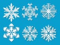 Set of six white paper cut out vector snowflakes on blue background. Royalty Free Stock Photo