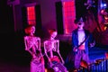 A set of skeletons and a pirate skeleton outside a haunted house on Halloween night in October