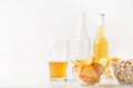 Set of snacks and beer for clients. Half glass of beer, empty and full bottle, nachos, chips and pistachios in glass Royalty Free Stock Photo