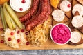 set of snacks: sausages, toast, sauerkraut, marinated onion and cucumber, baked potato. Top view Royalty Free Stock Photo