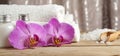 Set for spa treatments with lotions for skin, orchid flowers, bath salt and white towels Royalty Free Stock Photo