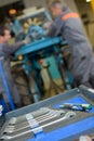 Set spanners in foreground mechanics at work behind Royalty Free Stock Photo
