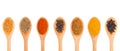 Set of spice in wooden spoons: fenugreek, cumin, chili pepper, allspice, masala, turmeric, black pepper